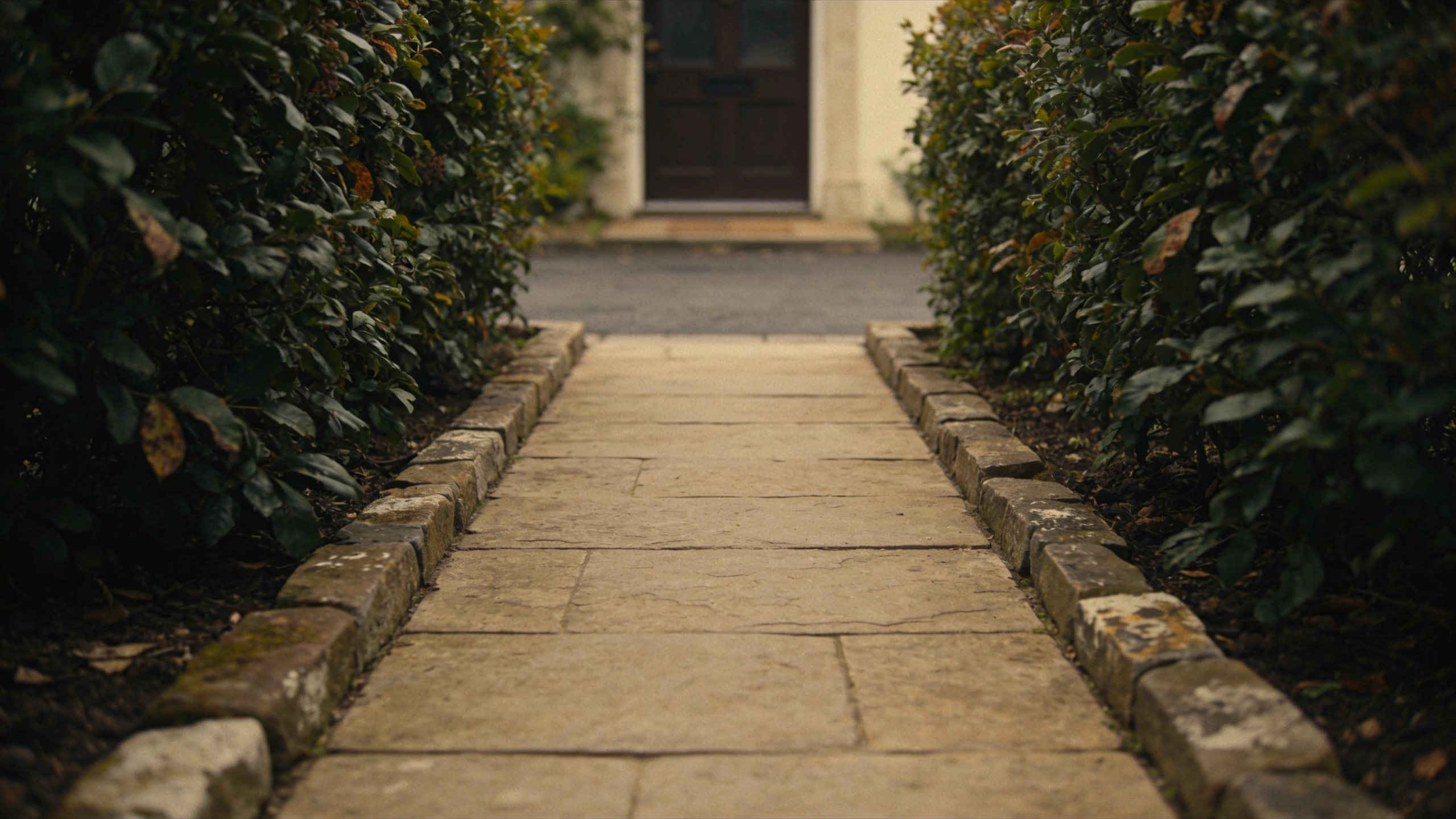 One paving material, one direct route, planting either side Straight wide stone path from pavement to front door with deep planted beds on both sides