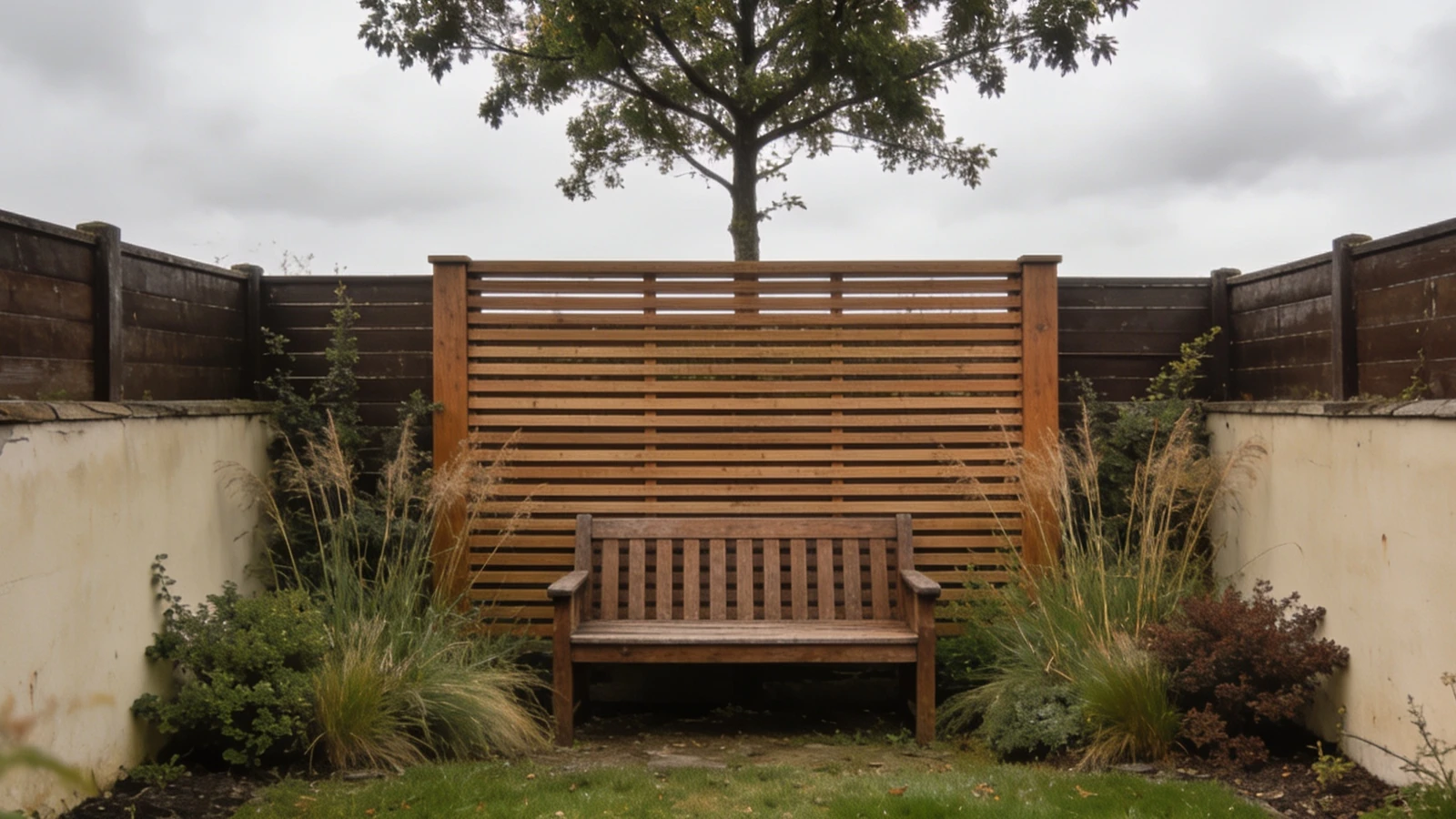 Seating area made private by a single slatted screen inside the boundary with a tree overhead