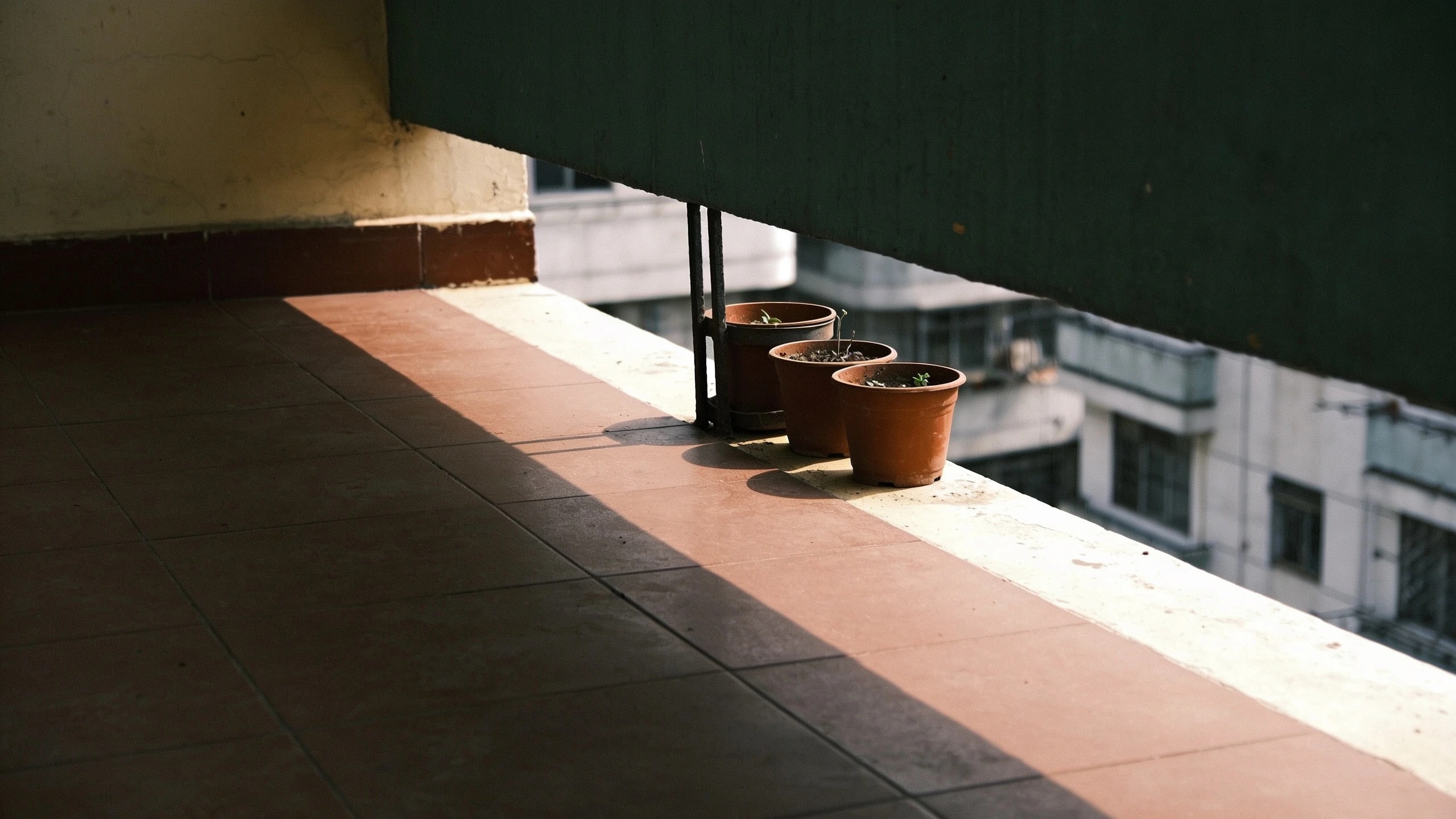 A balcony shaded by the floor above Balcony with a hard shadow from the overhanging floor above across most of the floor